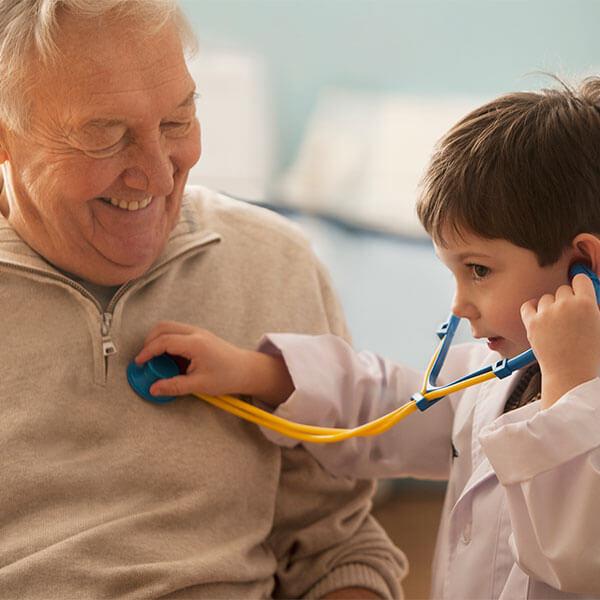 Child playing doctor with grandpa