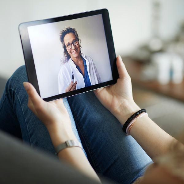 Woman sitting on couch consulting a doctor virtually