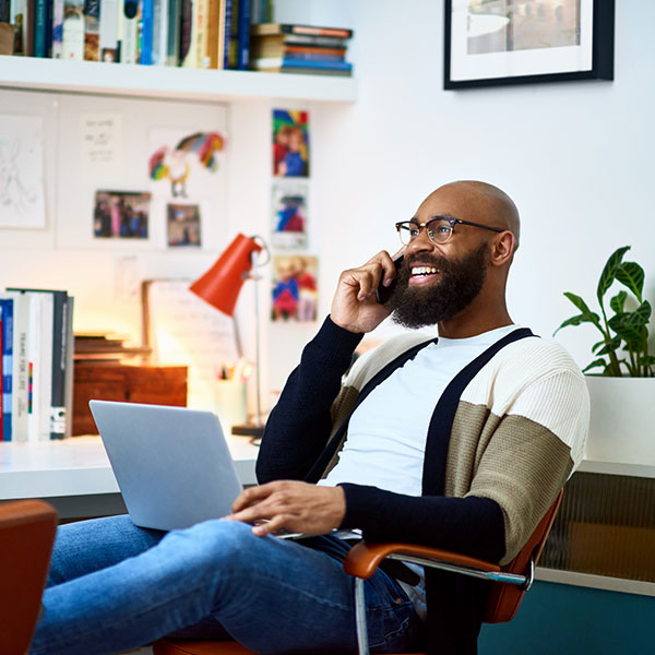 Man talking on the phone with a laptop