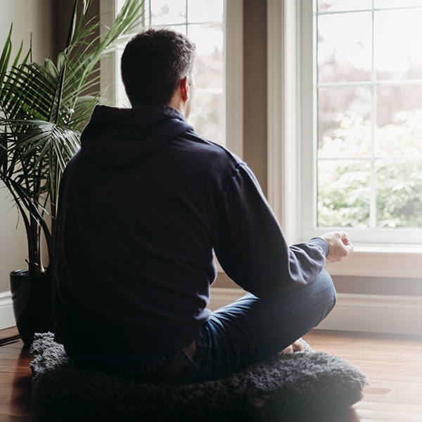 Man meditating by the window